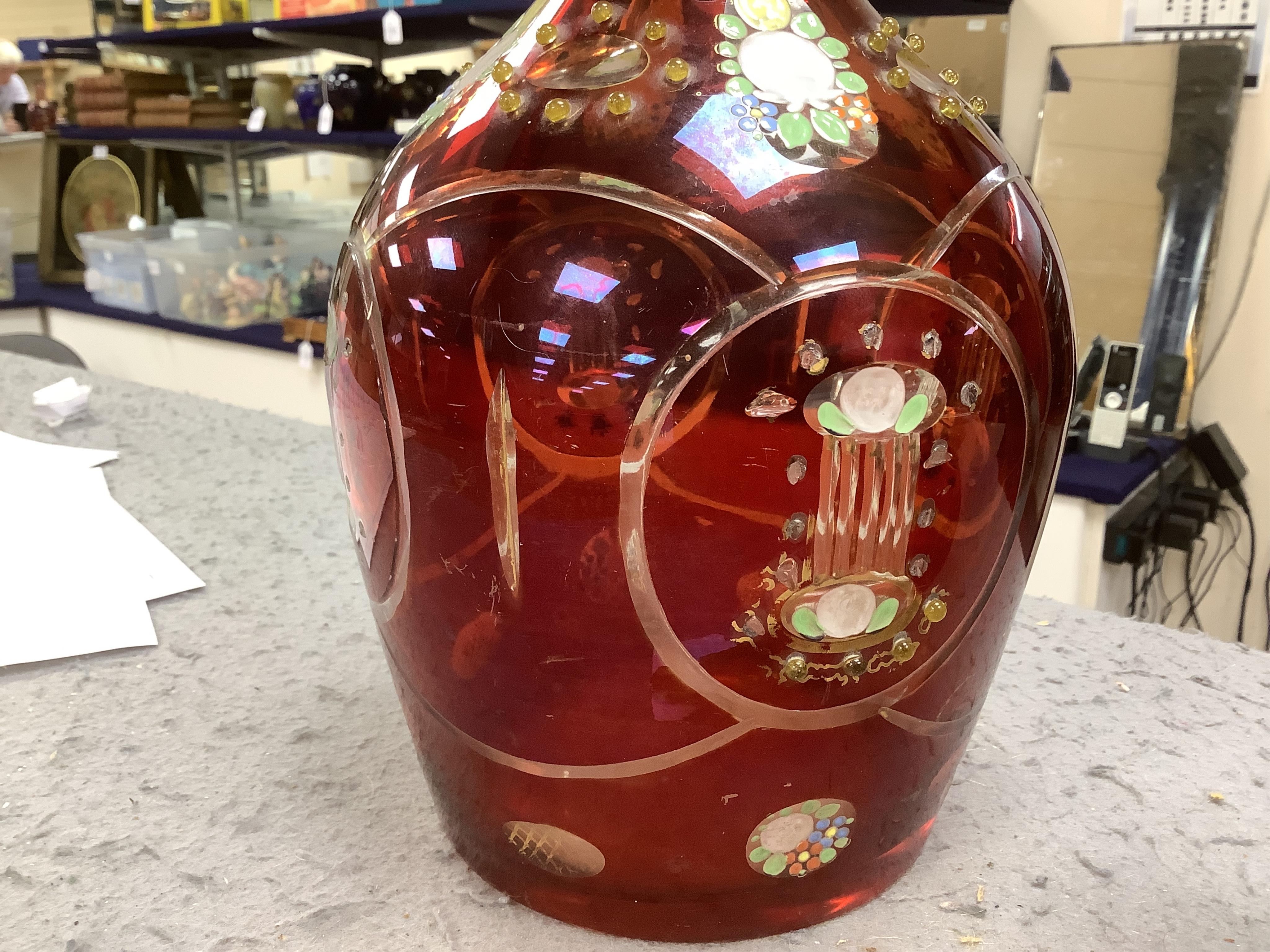 An early 20th century Bohemian overlaid and painted ruby glass decanter, 51cm. Condition - fair